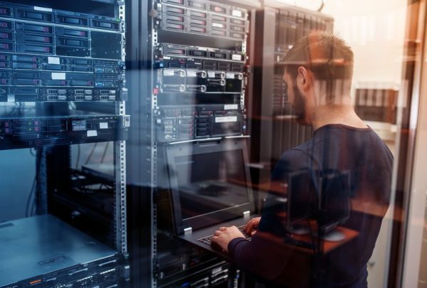 network engineer working in server room young it engeneer business man with thin modern aluminium laptop in network server room